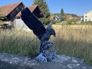betonfarbene adlerfigur in der rueckansicht von rechts
