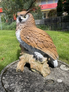 deko-eule als gartenfigur schraeg von rechts