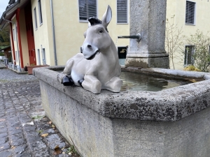 Grauer Esel als Gartenfigur in schräger Vorderansicht