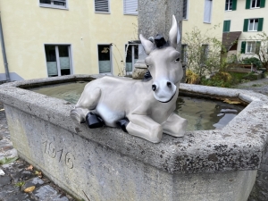 Graue Eselfigur liegend in vollständiger Frontansicht