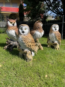 eulenfiguren als gartendeko in einer gruppenansicht