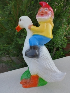 Lustiger Gartenzwerg, der eine Ente reitet 1
