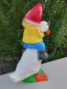 Lustiger Gartenzwerg, der eine Ente reitet 3