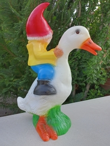 Lustiger Gartenzwerg, der eine Ente reitet 4