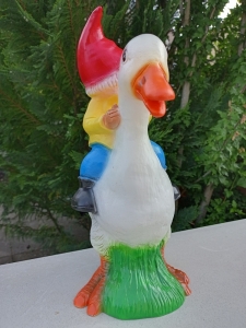 Lustiger Gartenzwerg, der eine Ente reitet 5