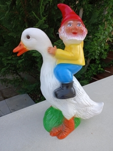 Lustiger Gartenzwerg, der eine Ente reitet 6