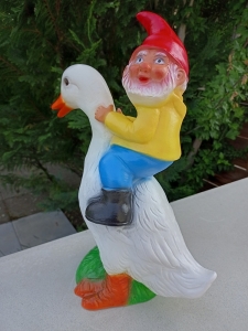 Lustiger Gartenzwerg, der eine Ente reitet 2