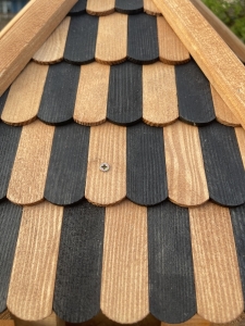 Detail der Dachschindeln am grossen Vogelhaus in Teak-Gruen